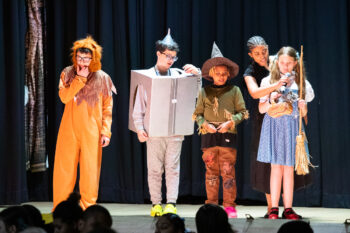 At The Maryland School for the Blind, five students shine on stage dressed as beloved characters from "The Wizard of Oz," bringing the story to life. With guidance from a staff member assisting one student with a prop, their talent and teamwork are on full display. Be sure to look out for more inspiring moments like this in our 2025 Summer newsletter!.
